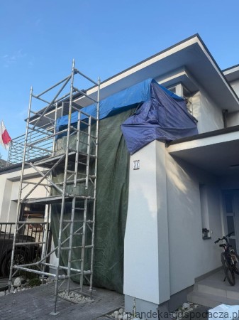 Plandeka HDPE 160 g/m² pokazana w użyciu na rusztowaniu. Chroni elewację przed wiatrem, deszczem i pyłem.